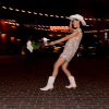 Woman dancing in white boots and white cowgirl hat