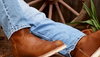 Image of a man in light denim wearing booths with a rubber sole