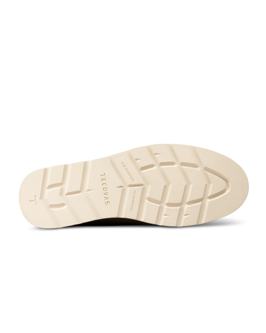 The Knox Lace Up Shearling in Sandstone Roughout. Cream-colored Sandstone Roughout boot sole with grooved tread pattern and embossed branding, viewed from the bottom against a white background.