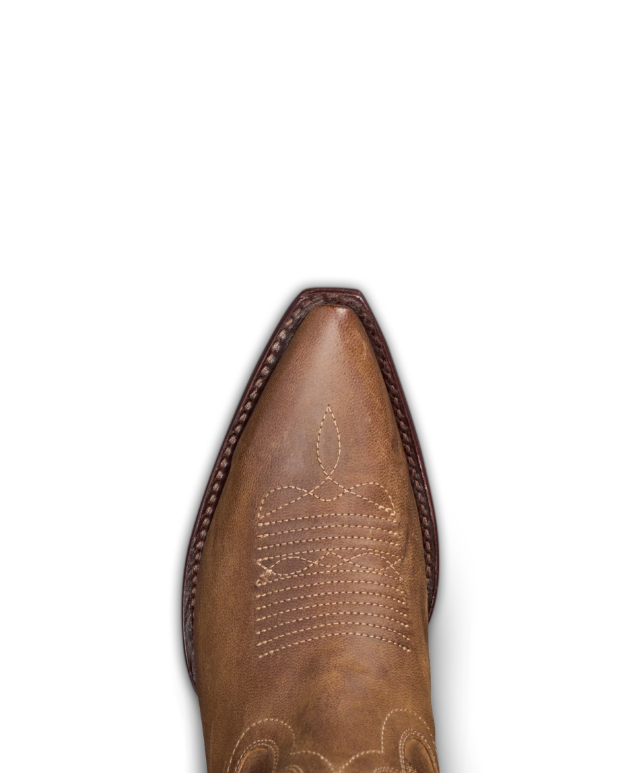 A close-up of a brown leather cowboy boot's pointed toe with intricate stitching on a black background.