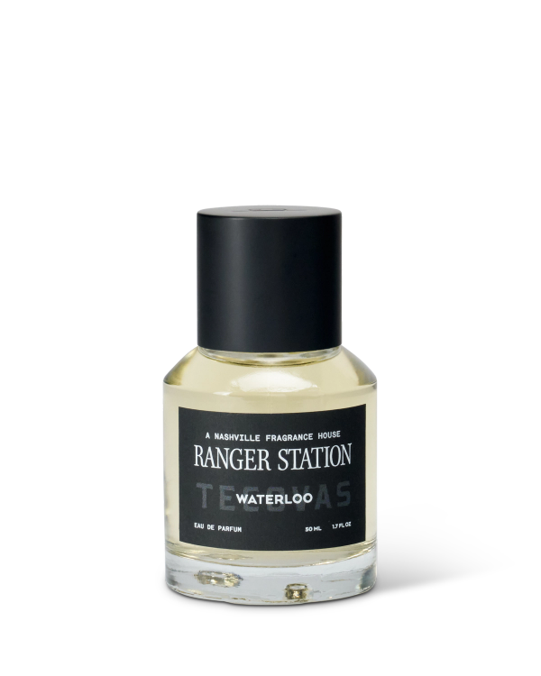 A clear glass bottle of Ranger Station Waterloo eau de parfum with a black cap and a black label featuring white text.