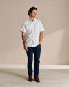 Full body image of man wearing jeans and a short sleeve pearl snap. ina photo studio