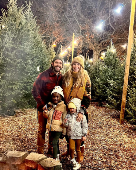Four people standing together in Christmas tree farm