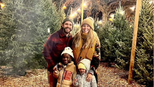 Four people standing together in Christmas tree farm