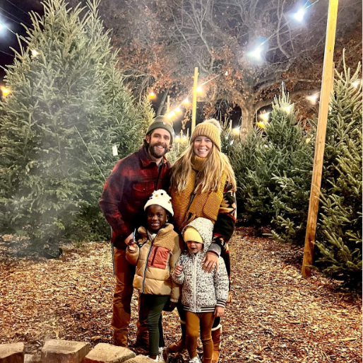 Four people standing together in Christmas tree farm