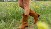 Woman in a field with wildflowers wearing suede boots