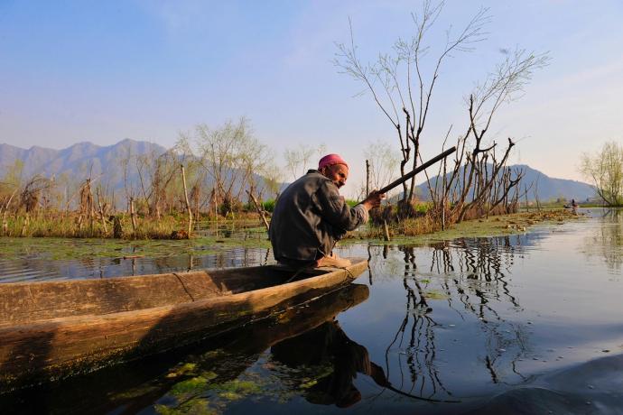 man on a tiny canoe in a pond