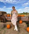 Women in pumpkin patch with white cowgirl boots