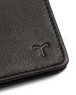 Close-up of a black leather wallet corner with a T logo embossed on the surface.