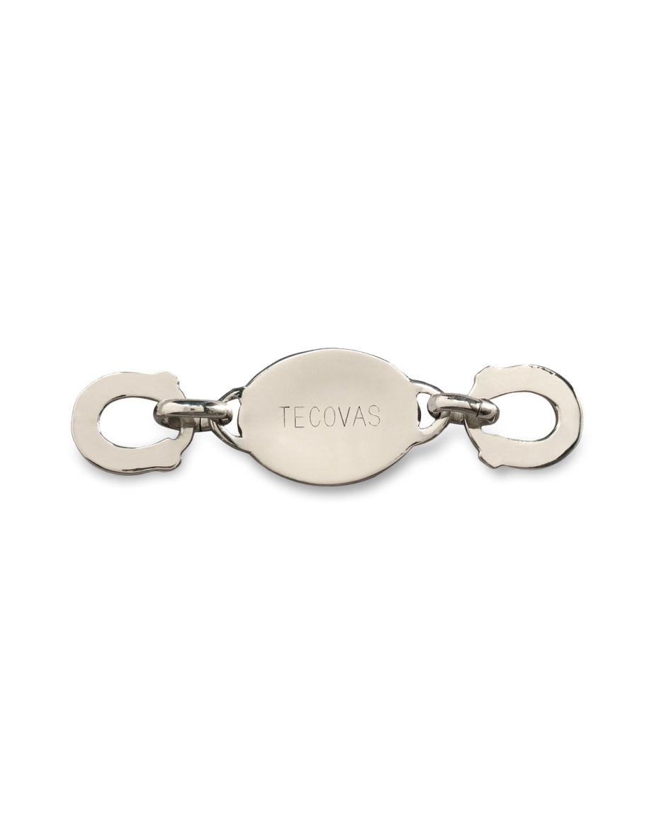 A silver metal clasp with two hooks on each end and an oval center engraved with the word "Tecovas.