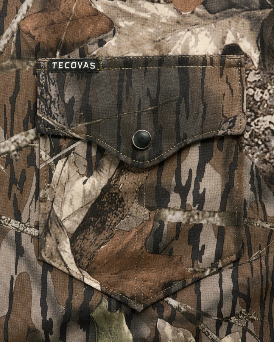 Close-up of a camouflage-patterned shirt pocket with a button flap and a small “Tecovas” label above the pocket.