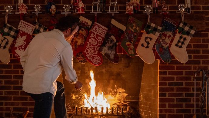 Man standing in front of a fireplace.