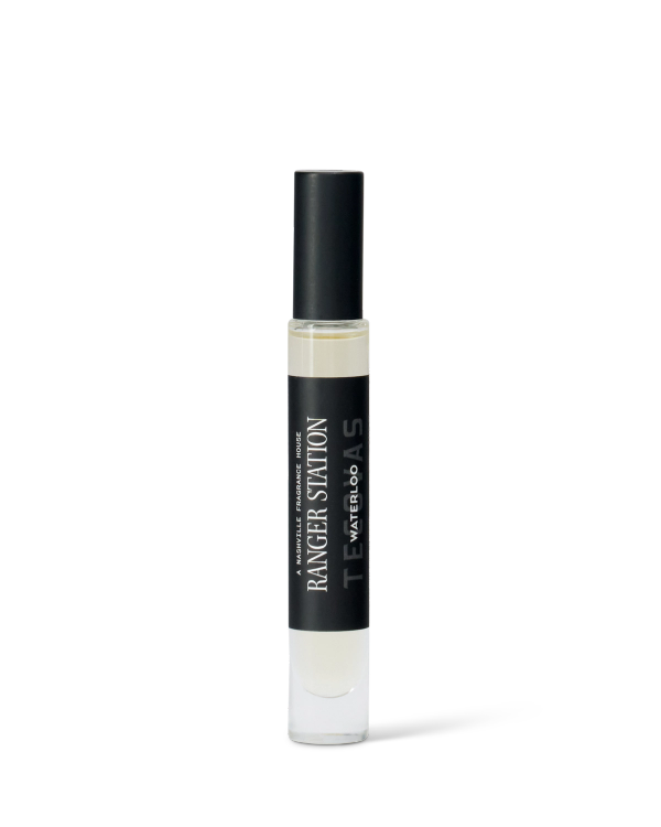 A clear glass perfume spray bottle labeled "Ranger Station Teakwood & Water" with a black cap, shown on a plain white background.