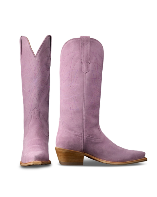 The Annie in Lavender Suede. Pair of tall, light purple Annie Suede cowboy boots with pointed toes, wooden heels, and decorative stitching, shown from side and front angles on a white background.