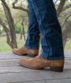 Man standing on porch in cowboy boots
