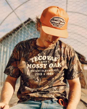 Front view of Tecovas x Mossy Oak Flat Brim Trucker - Rust on plain background