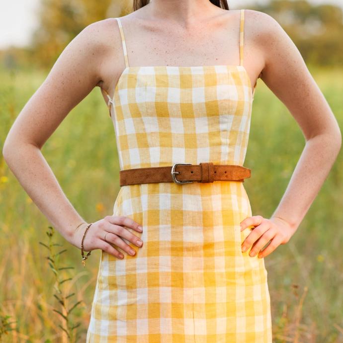 Woman in yellow and white plaid dress with sienna suede belt