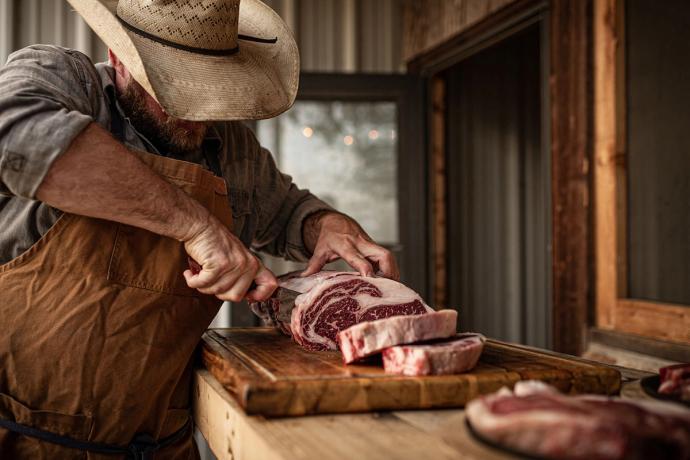 a man cutting large slabs of meat