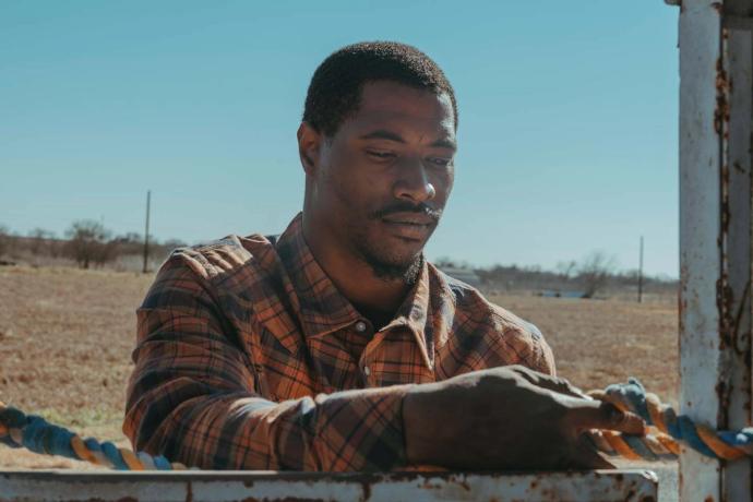 man tying a lead to a post