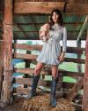 Woman holding chicken in barn wearing The Abby boots - Tecovas