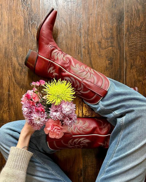 Woman sitting with flowers wearing the Annie Scarlet