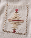 Close-up of a cream-colored knitted fabric with a square patch featuring a geometric design in brown, beige, and red.