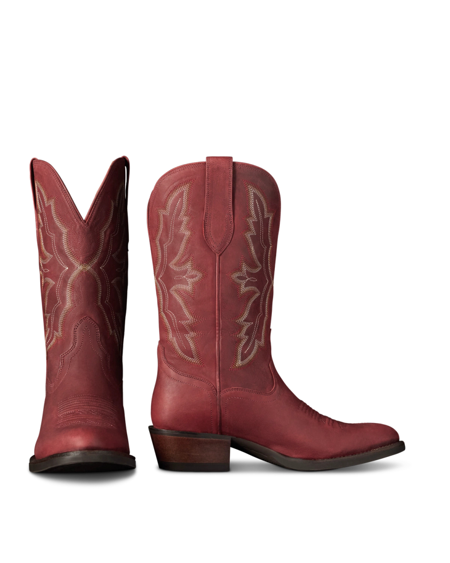 The Britt in Redwood Goat. Pair of red leather Redwood Goat cowboy boots with decorative stitching, stacked heels, and pull tabs, shown upright with one boot facing forward and the other in profile against a white background.