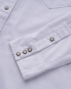 Closeup view of the sleeve of a women's white pearl snap