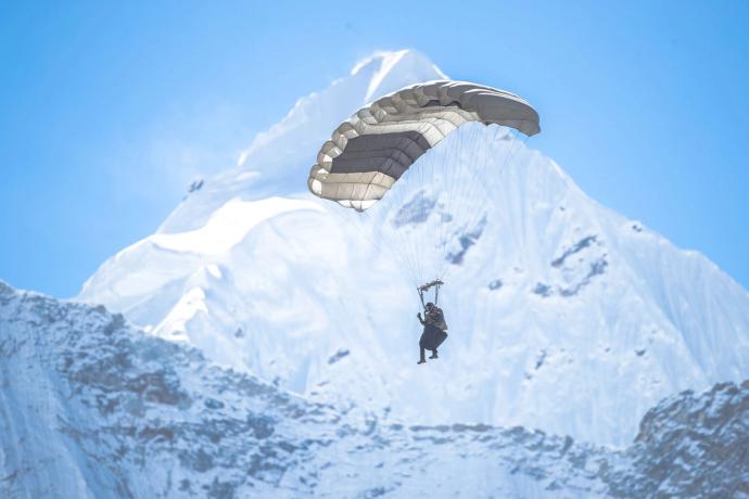 man paragliding over mountain