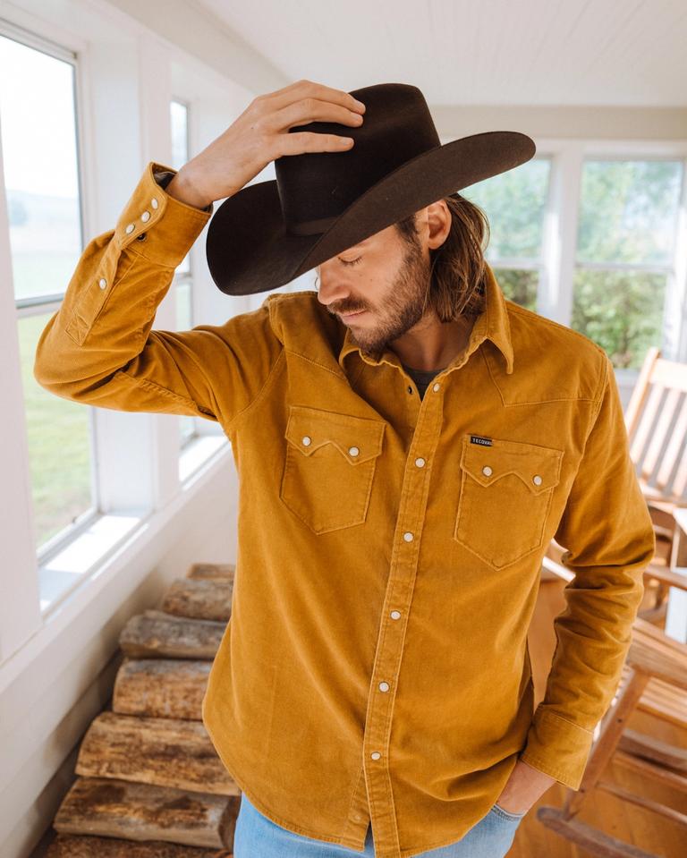 Cowboy hat, jeans in a mustard yellow button down