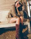 Woman in barn wearing Kristopher Brock dress and red Annie boots