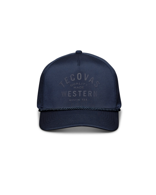 Navy blue trucker hat with mesh back, black rope detail above the brim, and "Tecovas Quality Made Western Austin, Tex." printed on the front.