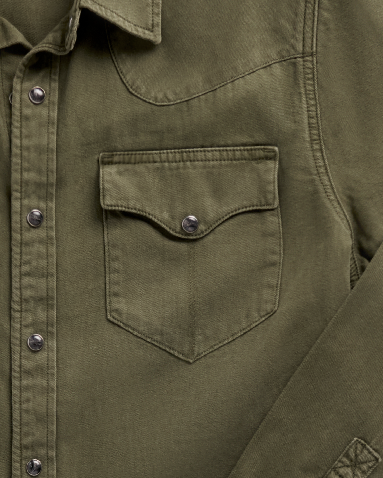 Close-up of a Tecovas olive green western shirt showing a chest pocket with snap closure and snap-button placket.