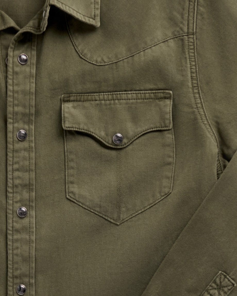 Close-up of a Tecovas olive green western shirt showing a chest pocket with snap closure and snap-button placket.