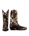The Sadie in Hair on Hide Hair on Hide / Cowhide. A pair of brown and white Hair on Hide / Cowhide cowboy boots with pointed toes and angled heels, shown from the side and back.