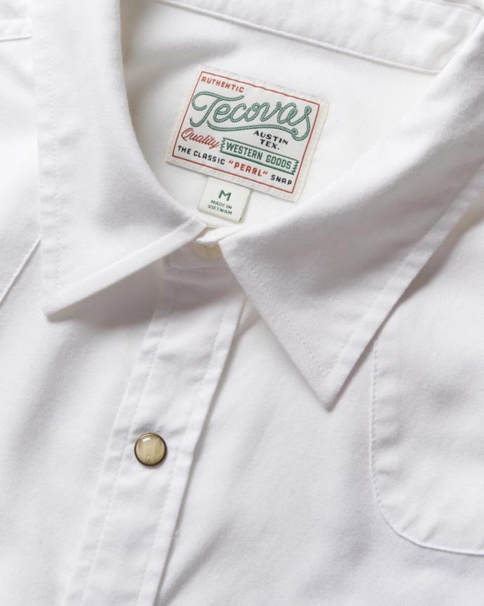 Closeup of the details of a white pearl snap shirt