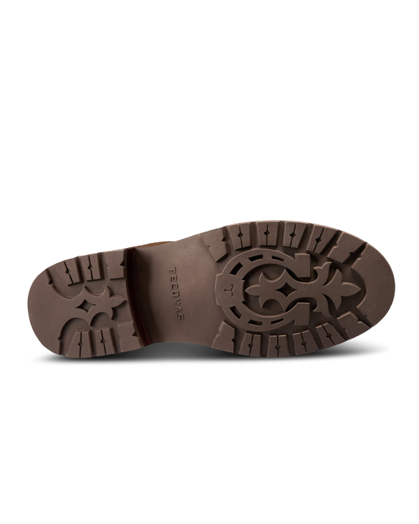 Brown shoe sole viewed from below, featuring a patterned tread design and the word “TAFT” embossed in the center—an essential detail in the refined craftsmanship of The Chelsea Cowhide collection in Cafe Cowhide.