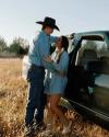 Couple leaning against truck wearing denim outfit and boots