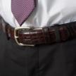 Black cherry crocodile belt close up on belt buckle around a man's waist