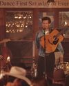 Man singing and playing guitar in a dance hall