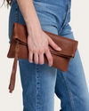 Closeup of hand holding Leather Clutch in Fawn