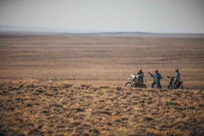 three cowboys on dirt bikes in the desert