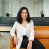 A woman sitting on an orange couch in an office.