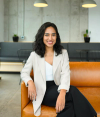 A woman sitting on an orange couch in an office.