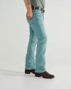 A person wearing light blue jeans, a grey belt, and dark brown cowboy boots, standing with one hand in their pocket against a plain background.