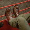 Man wearing brown square toe boots at a rodeo