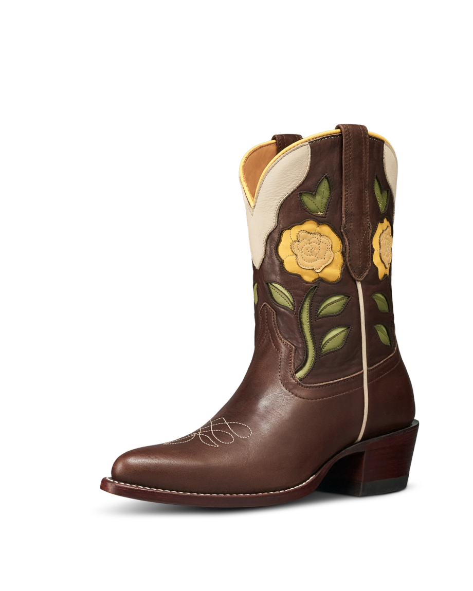 Truffle brown leather cowboy boot with yellow floral embroidery, green leaves, cream trim, and a stacked heel—The Jolene Cowhide—shown on a white background.