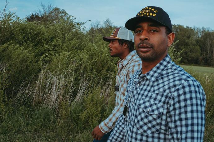 two men walking in a field