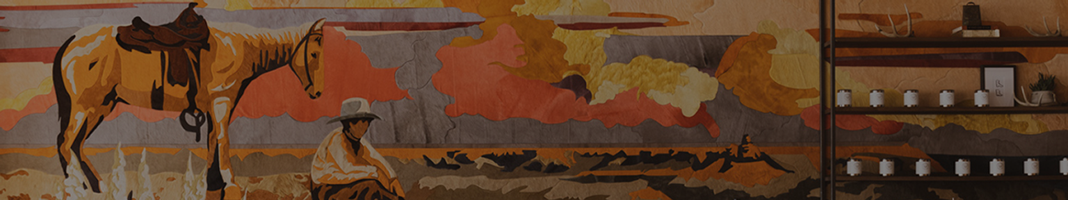 A mural depicting a cowboy sitting near a saddled horse in a desert landscape with shelves of small jars and decor on the right side.