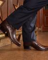 man wearing brown crocodile boots
